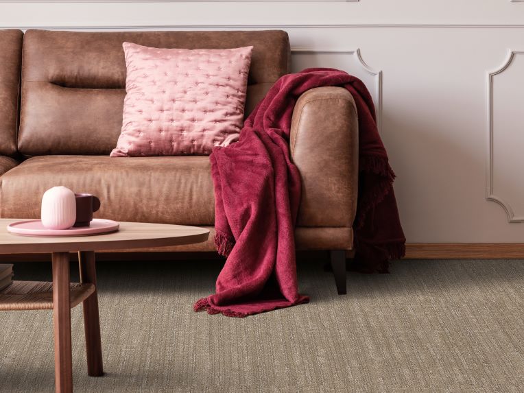 textured brown carpets in a stylish living room with leather couch and pink accents